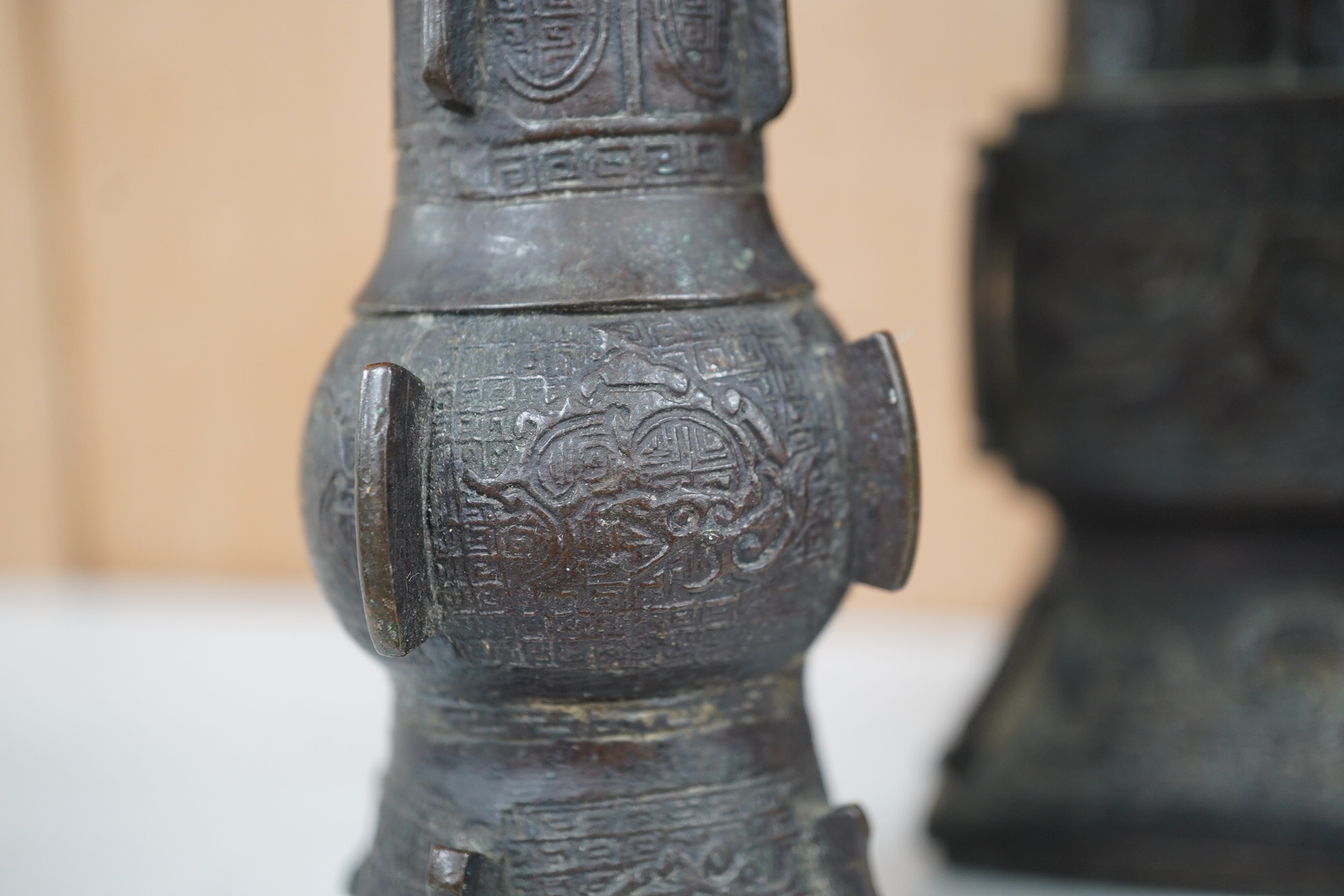 A pair 17th/18th century Chinese archaistic bronze gu vases, and a similar square vase, fanggu, Ming dynasty, tallest 18cm. Condition - poor to fair